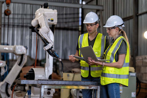 In robotic training instructor teach girl engineer to program robot arm ...