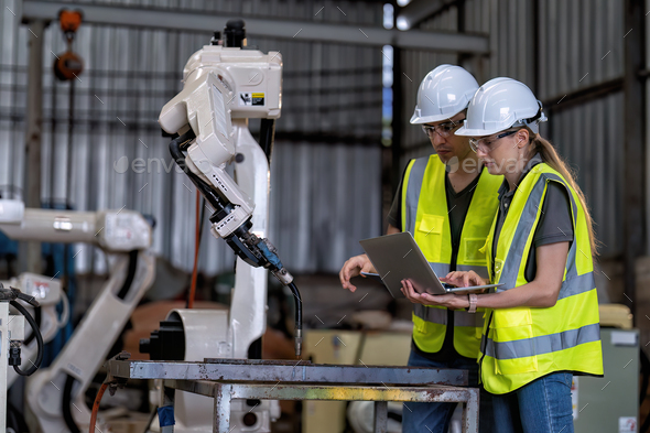 In robotic training instructor teach girl engineer to program robot arm ...