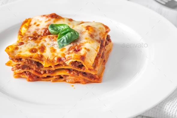 Portion of lasagne on white plate - Stock Photo - Images
