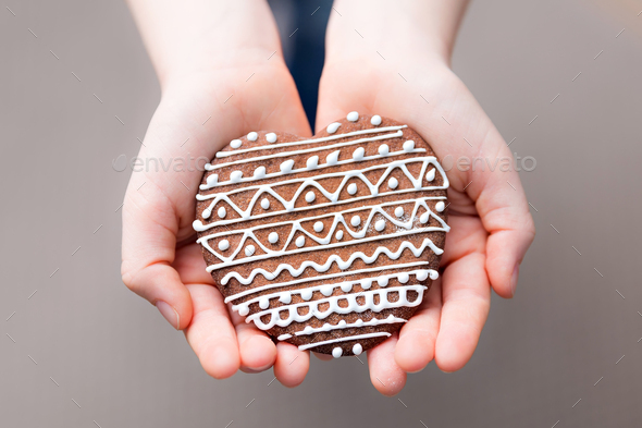 Gingerbread cookie in a hand - Stock Photo - Images