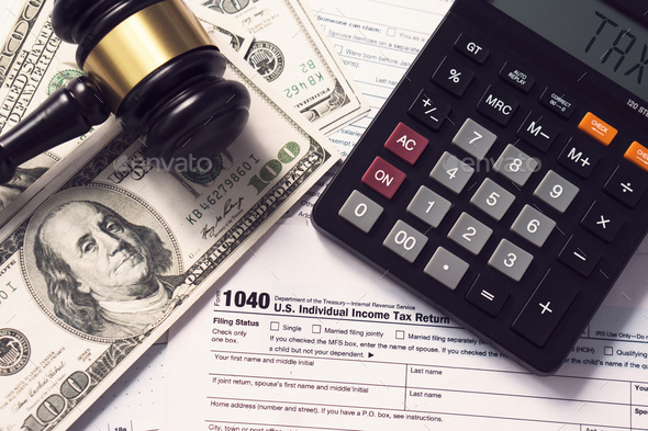 Tax concept.Calculator with taxes text with money on 1040 tax form.The new year tax concept. - Stock Photo - Images