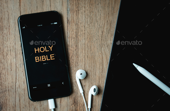 open bible with phone and headphones,Concept listen the words of God.Bible, phone,lapto