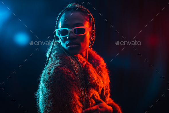 Black ethnic woman with braids with blue and red led lights, portrait in fur coat