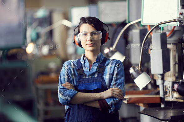 Young woman in ear protectors at factory