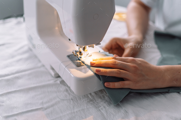 Lady stitching the edges of the fabric of a sewing machine