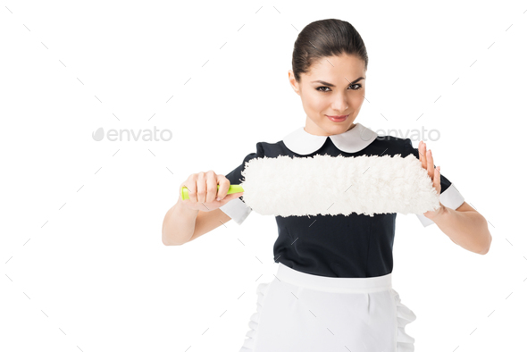 Professional maid in uniform holding duster isolated on white