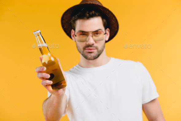 handsome young man wearing sunglasses sitting with bottles of red