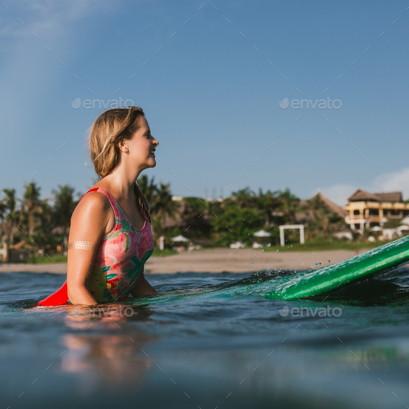 side view of young attractive woman in swimming suit resting on