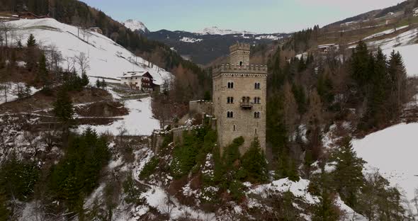 Superb orbit of the amazing Gernstein Castle, it is located over a hill in the Dolomites winter land alt