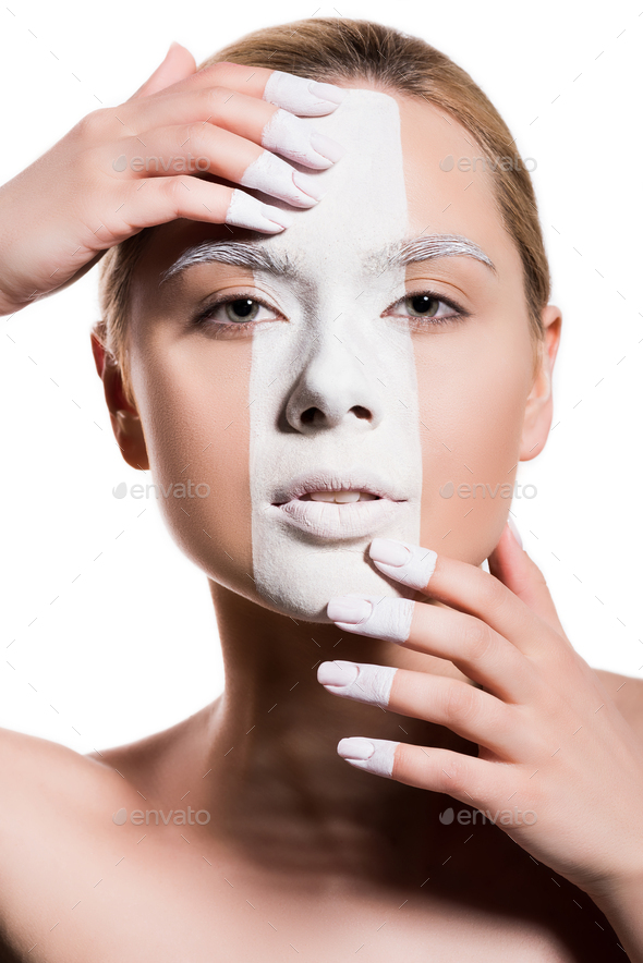 attractive woman with white paint on face touching forehead and chin