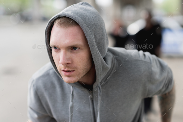 close-up shot of young hooded thief running from police
