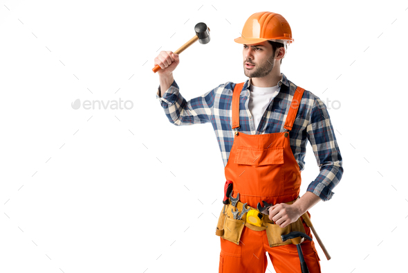 Bearded workman in orange overall and hardhat using hammer isolated on white