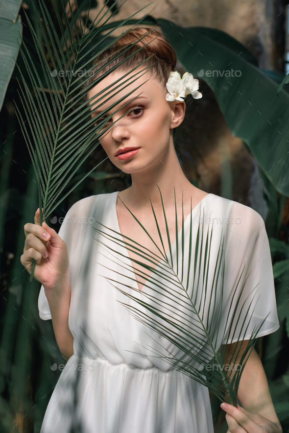 Beautiful Girl In White Summer Dress Posing With Tropical Palm Leaves