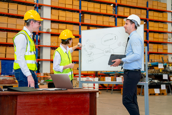 Warehouse worker woman write on white board to explain about project workflow and plan to team