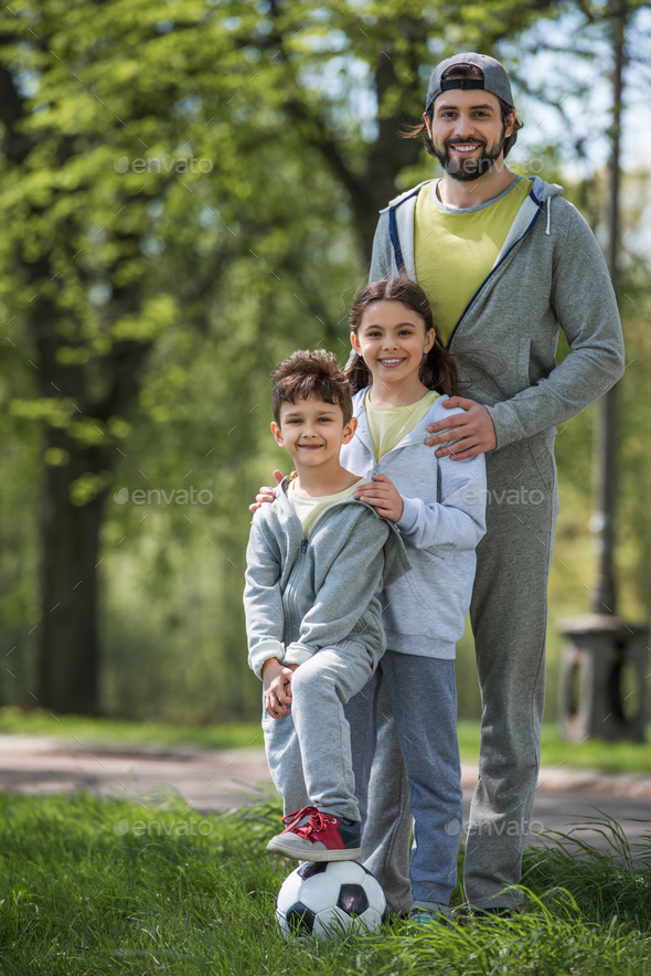 sportive family with soccer ball in park
