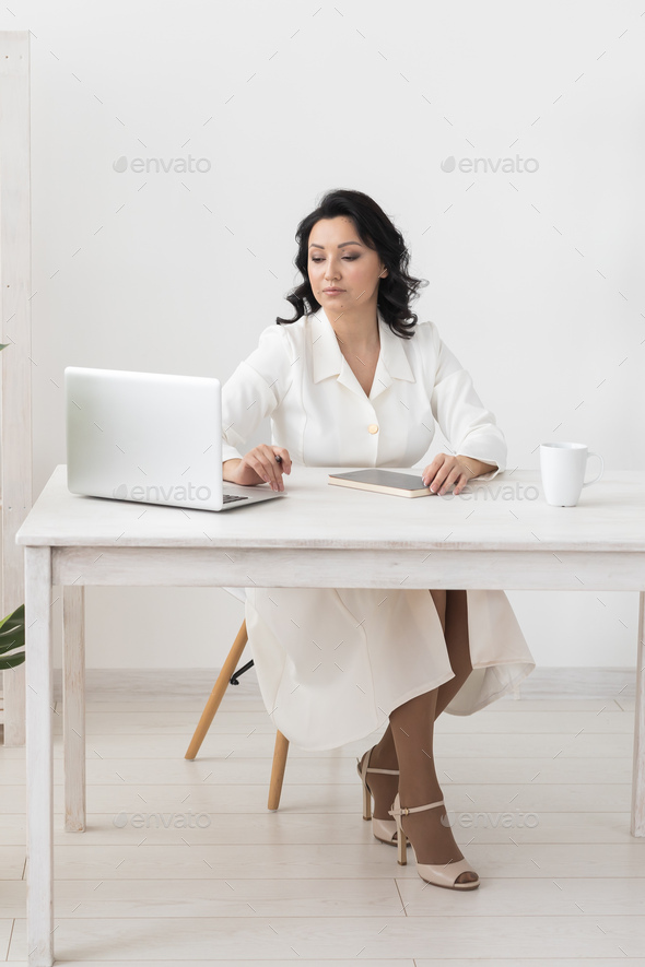 Portrait business woman in white suit working in office laptop computer