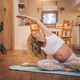 Young pregnant woman doing prenatal yoga at home on a fitness mat - PhotoDune Item for Sale