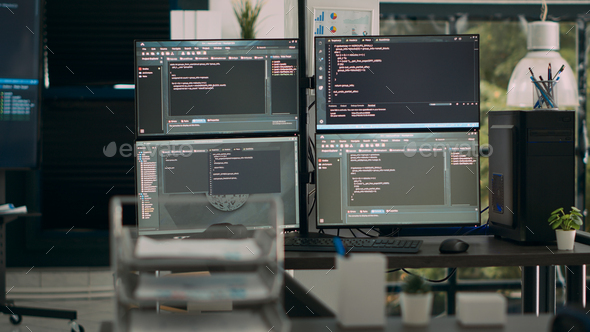 Multiple screens showing programming code in empty software it agency desk