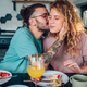 Couple eating breakfast together while sitting at table at home - PhotoDune Item for Sale