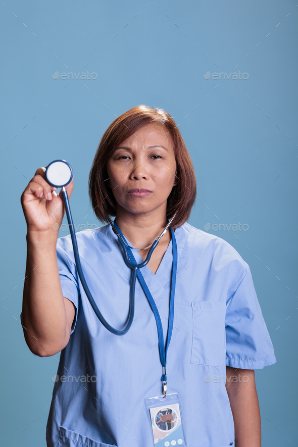 Medical Assistant Wearing Blue Coat During Checkup Visit Holding 