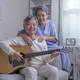 Portrait of Asian senior couple singing favorite song while playing on guitar at home.  - PhotoDune Item for Sale
