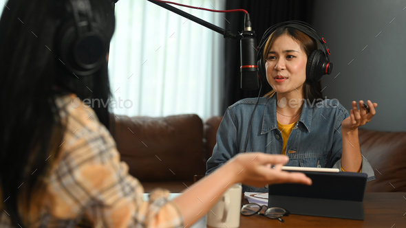 Woman radio host discussing various topics with her guest while streaming live audio podcast.