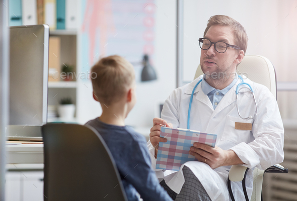 Pediatrician asking little boy about health complaints