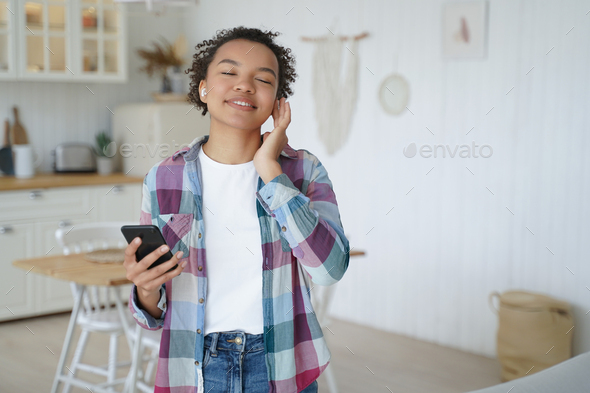Teenage girl enjoying music in wireless earphones. Having fun and recreation concept.