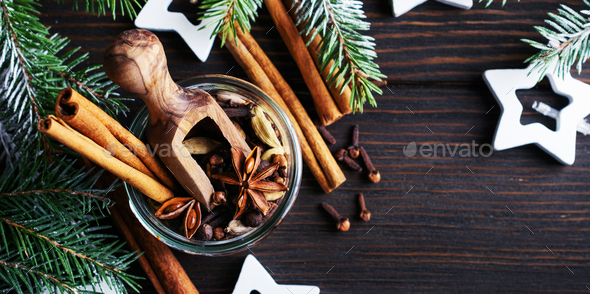 Mix of mulled wine seasonings in a jar of anise, cardamom, allspice, cinnamon sticks, cloves on a wo