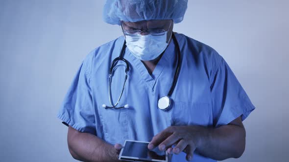 Doctor Wearing Surgical Scrubs Using Wireless Tablet 21