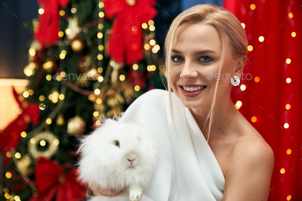 Cheerful, happy lady holding white, furry rabbit. Stock Photo by ...