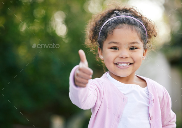 I will always say yes to fun. Portrait of an adorable little girl showing thumbs up outdoors.