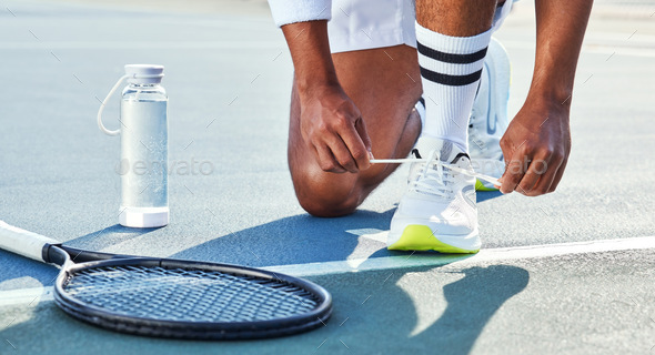 Cropped shot of an unrecognisable man kneeling down to tie his shoelaces before tennis practice
