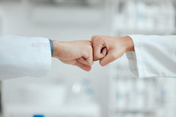 We can do this. Shot of two scientists fist bumping one another.
