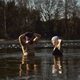 Caucasian couple standing and talking in frozen lake with hands raised - PhotoDune Item for Sale