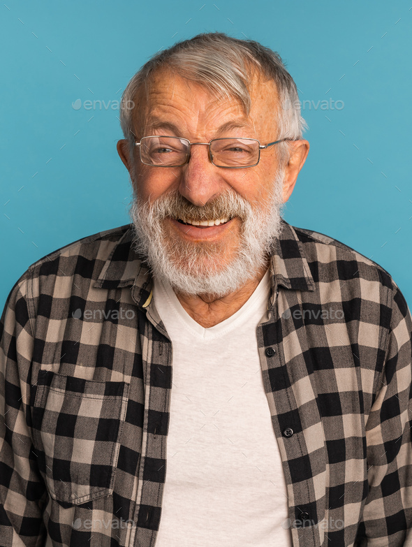 Portrait retired old man with white hair and beard laughter excited over blue color background - Stock Photo - Images