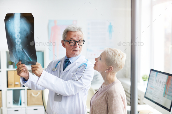 Doctor explaining spinal problems to senior woman