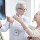 Mature lady discussing core x-ray image with doctor - PhotoDune Item for Sale