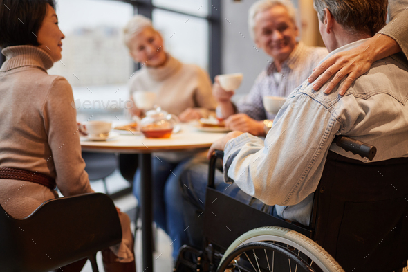 Senior people visiting friend in wheelchair