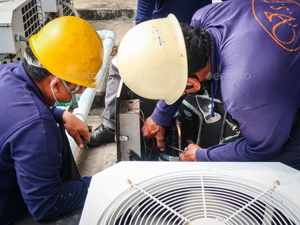 Maintenance man repair air conditional and air compressor of the factory.