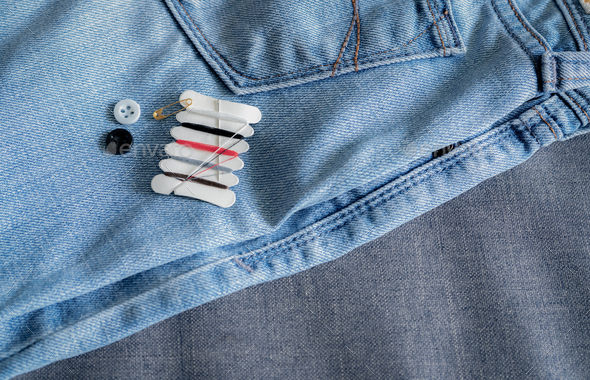 Hotel sewing kit on jeans. Small portable thread repair emergency kit with needles, buttons, threads