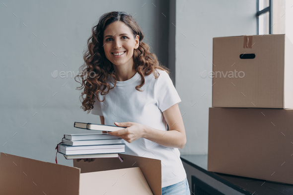 Excited student in residential room. Happy european woman opening and unpacking boxes. - Stock Photo - Images