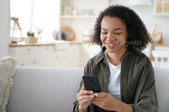 Happy female hold phone chat in social network read good news, shopping via  online store app at home Stock Photo by StudioVK
