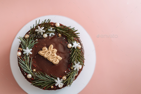 Chocolate cake decorated with Christmas tree branches and numbers 2023 - Stock Photo - Images