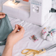 Lady fixes fabric with needles in front of a sewing machine - PhotoDune Item for Sale