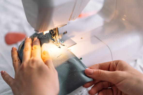 Lady stitching the edges of the fabric of a sewing machine - Stock Photo - Images