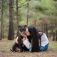 Young caucasian woman kissing her mixed breed dog at a pine forest. - PhotoDune Item for Sale