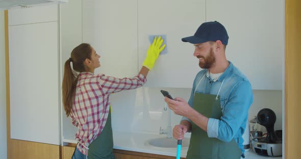 Man and Woman As a Professional Cleaners in Uniiform Having Fun During the Work on the Kitchen.