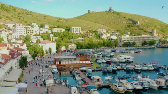 Drone Flight Over a Seaport with Yachts and Mountain Views