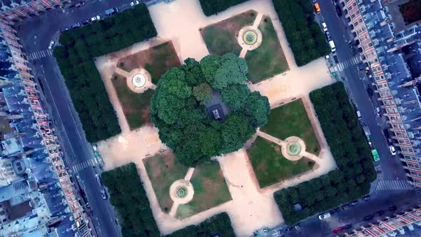 Rolling top down view of Place des Vosges from drone. Geometric shape of footpaths at symmetrical sq alt